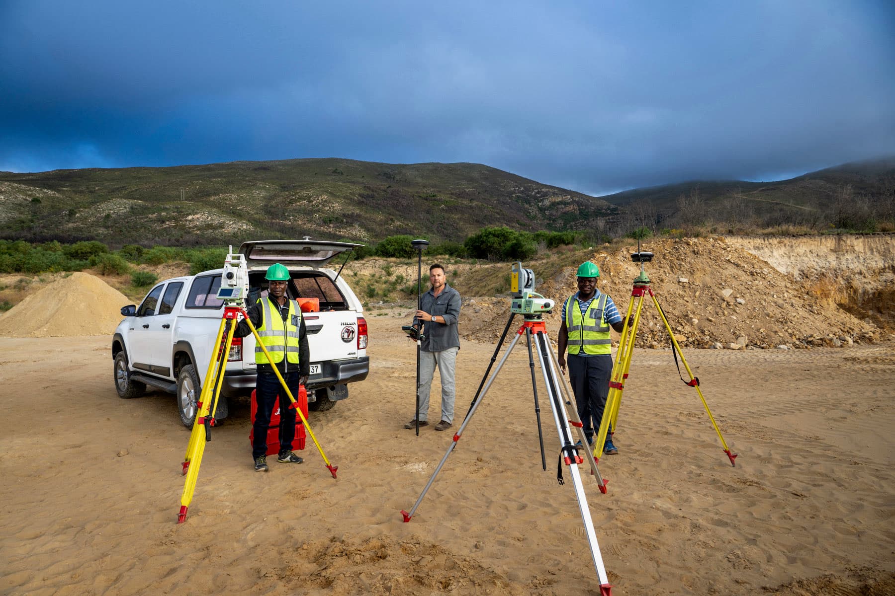 Iqela leGeoSurv kwindawo yomsebenzi line-total station ezenzekelayo, iirover zeGNSS kunye nebhakkie yenkampani.